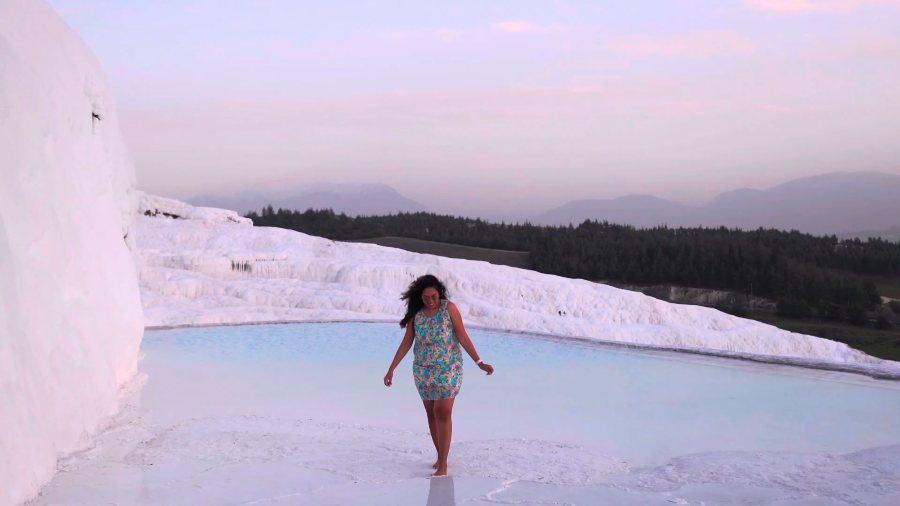 Meenu walking through a shallow white travertine pool in the evening light