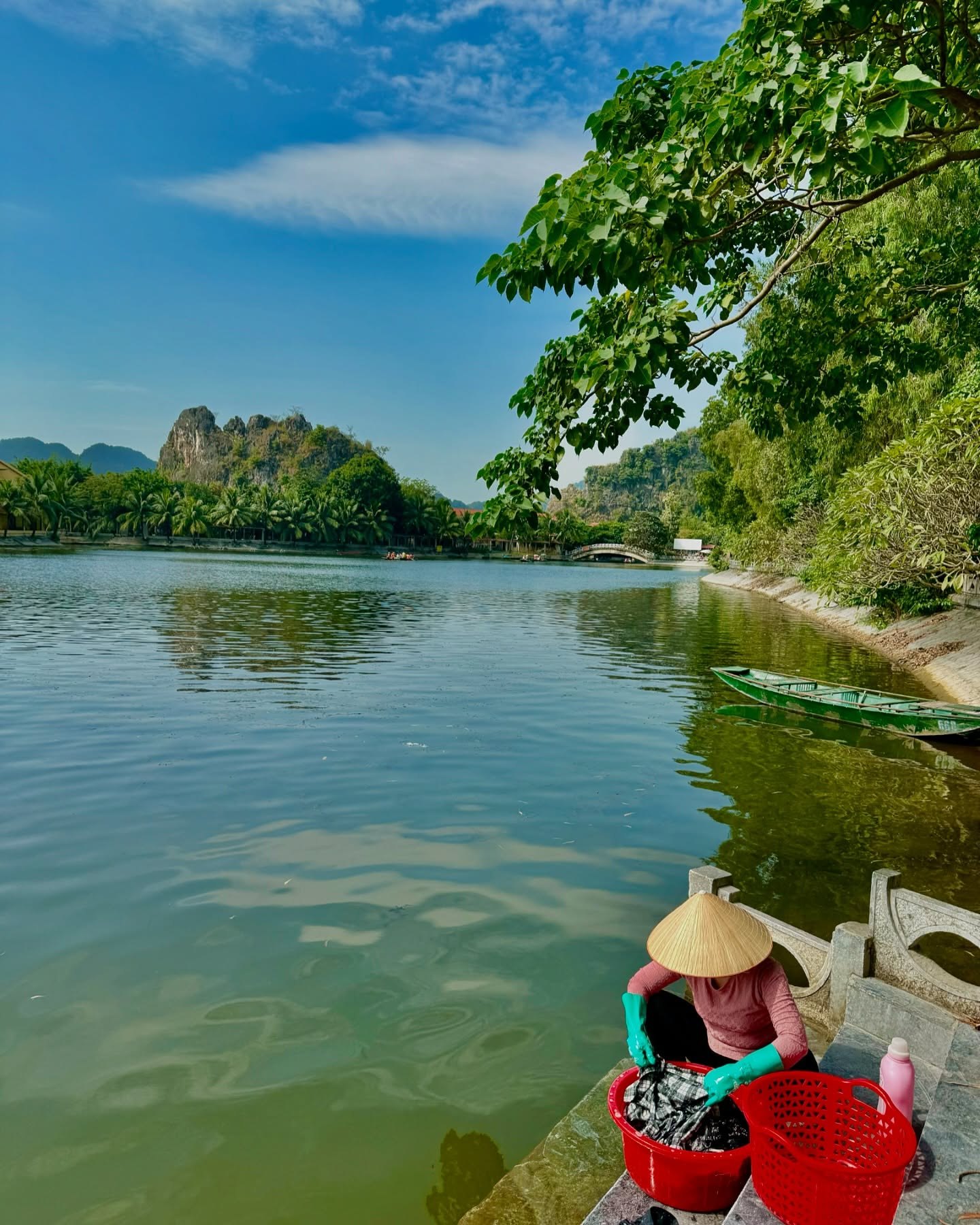 The river at Tam Cốc, with limestone peaks rising behind the trees