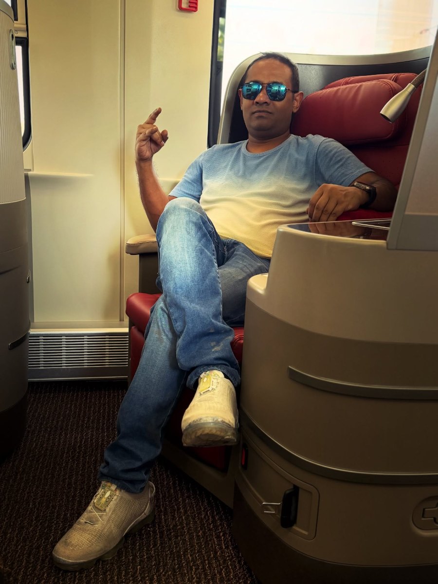 Praddy stretched out in a red business-class seat on the Laos–China Railway