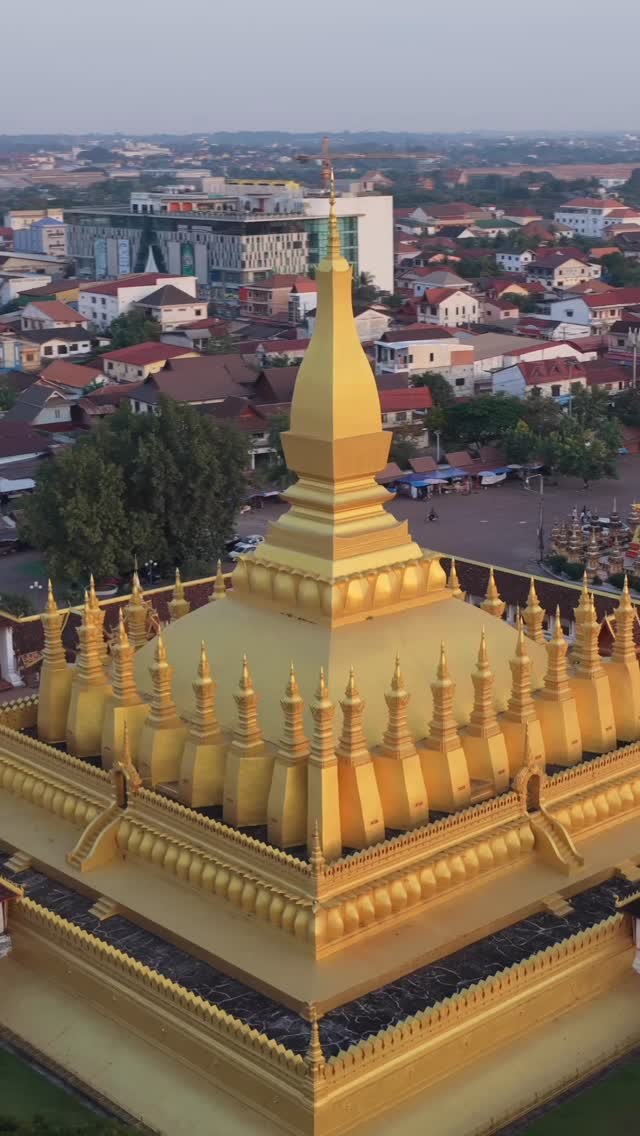 Drone view of the golden stupa of Pha That Luang, with Vientiane spread out behind