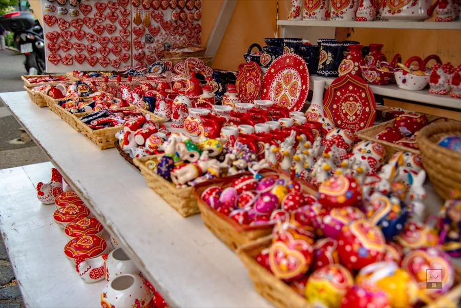Baskets of red hearts and painted souvenirs on a shop table